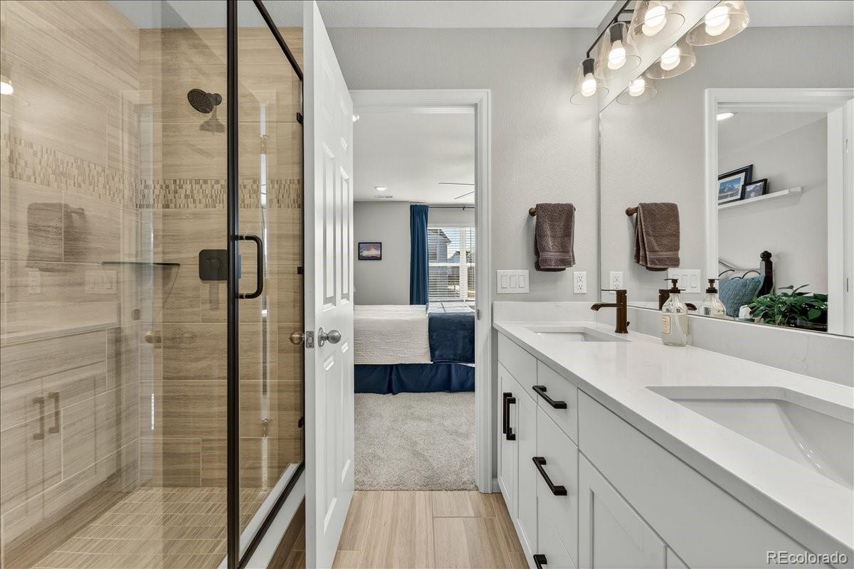 9793 Banner Peak Loop Littleton, CO 80125 - Photo 9 of 42 a spacious bathroom with a double vanity sink mirror and shower