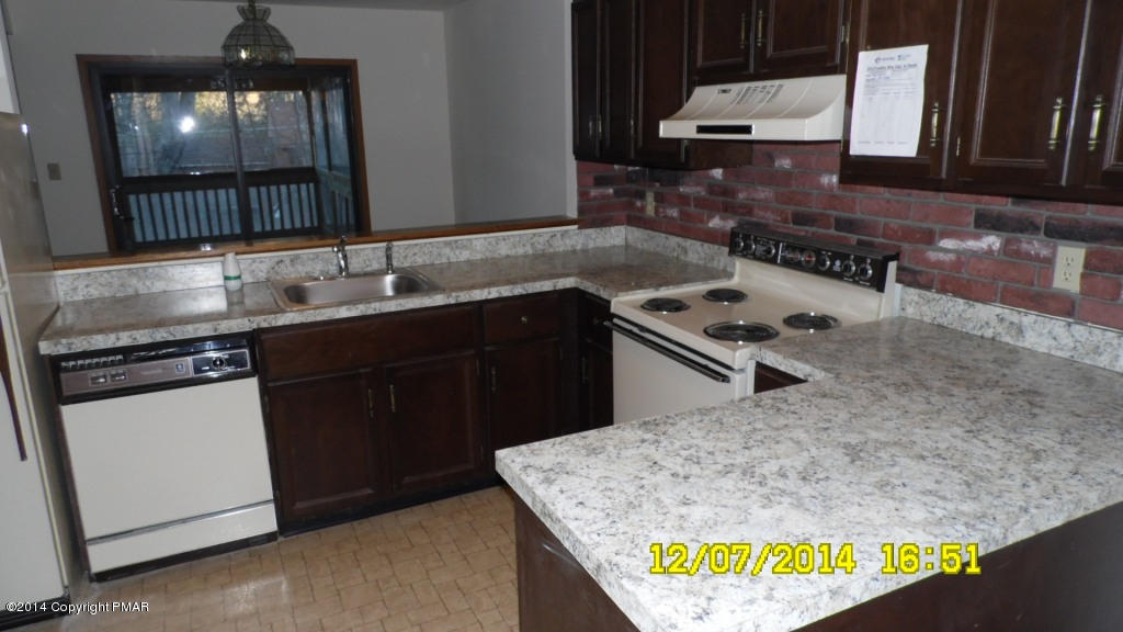216 Falls Circle Bushkill, PA 18324 - Photo 4 of 11 a kitchen with kitchen island granite countertop a sink a stove and a wooden floor