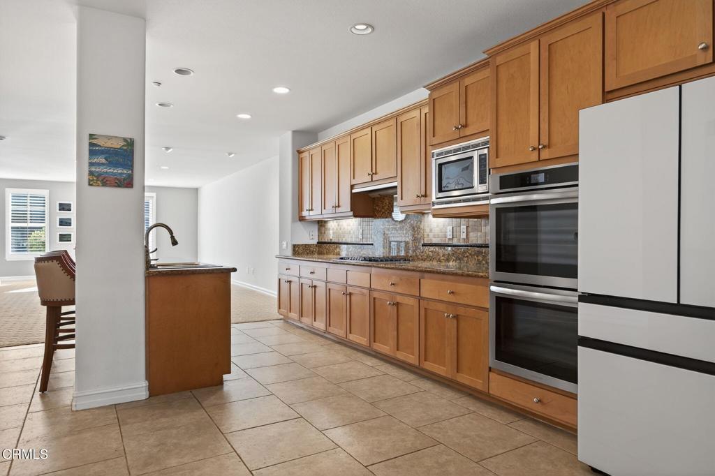 1423 Windshore Way Oxnard, CA 93035 - Photo 17 of 77 a kitchen with granite countertop a refrigerator and a stove top oven
