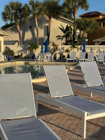 a view of a patio with chairs and umbrellas