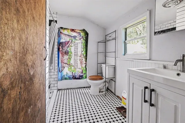 a bathroom with a sink a toilet and a shower curtain