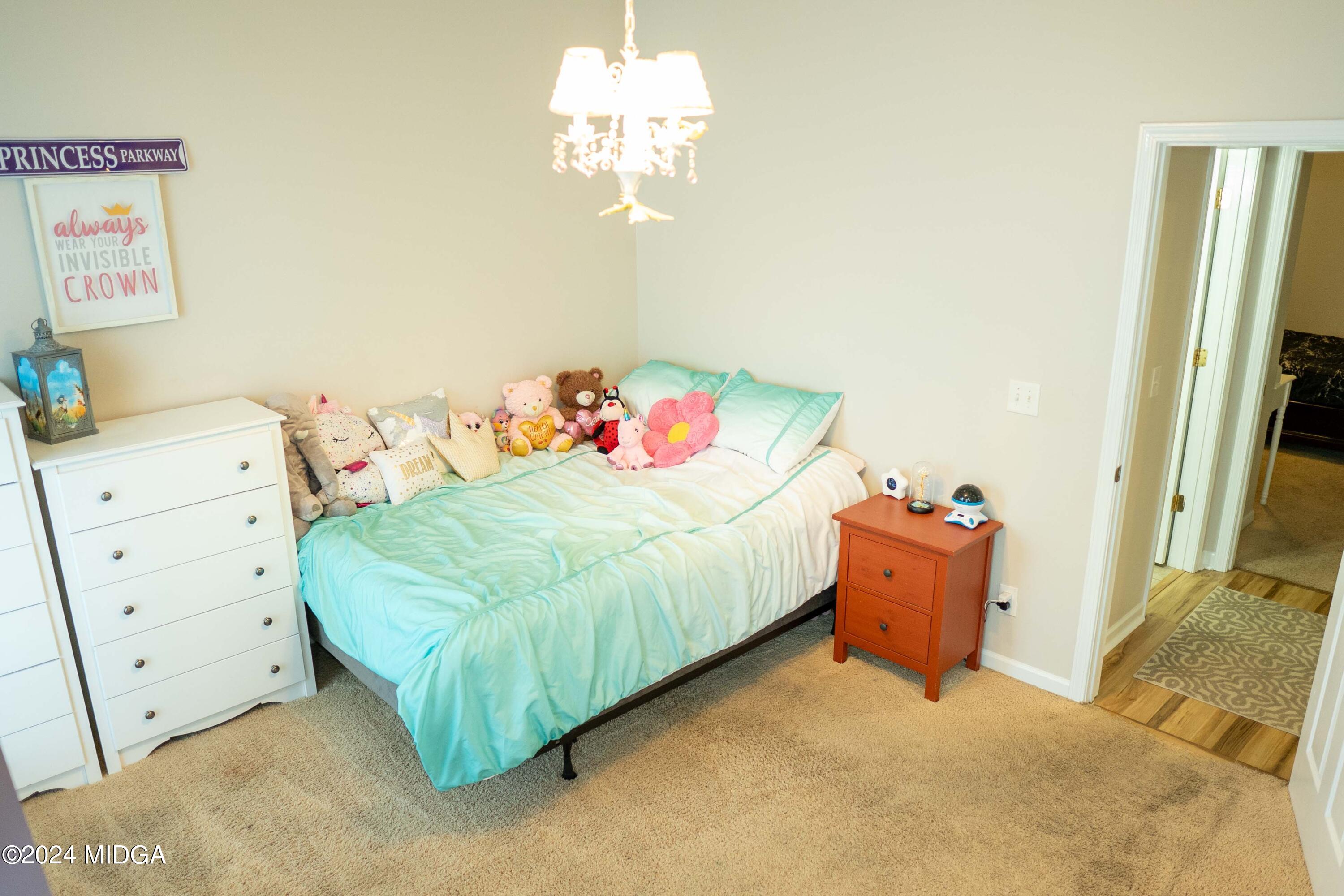 105 Windermere Circle Perry, GA 31069 - Photo 23 of 48 a bedroom with a bed and a chandelier