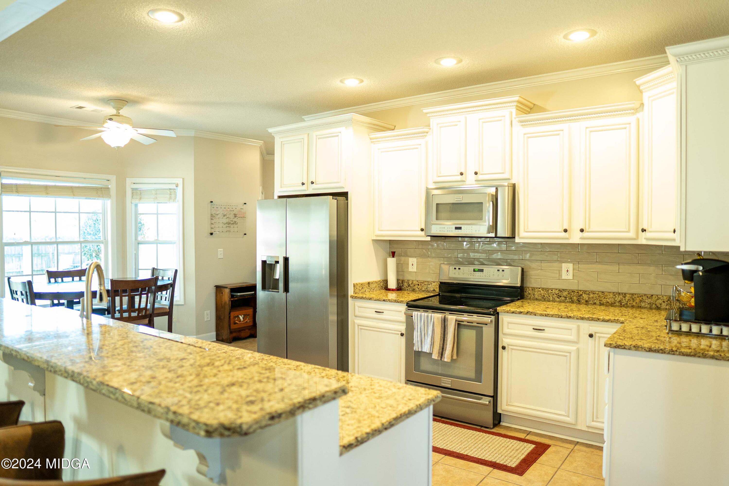 105 Windermere Circle Perry, GA 31069 - Photo 10 of 48 a kitchen with granite countertop a sink stove and refrigerator