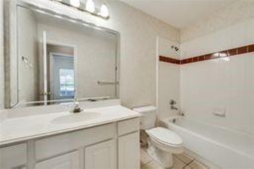 8417 Catskill Court Plano, TX 75025 - Photo 11 of 17 a bathroom with a sink a toilet a mirror a bathtub and shower