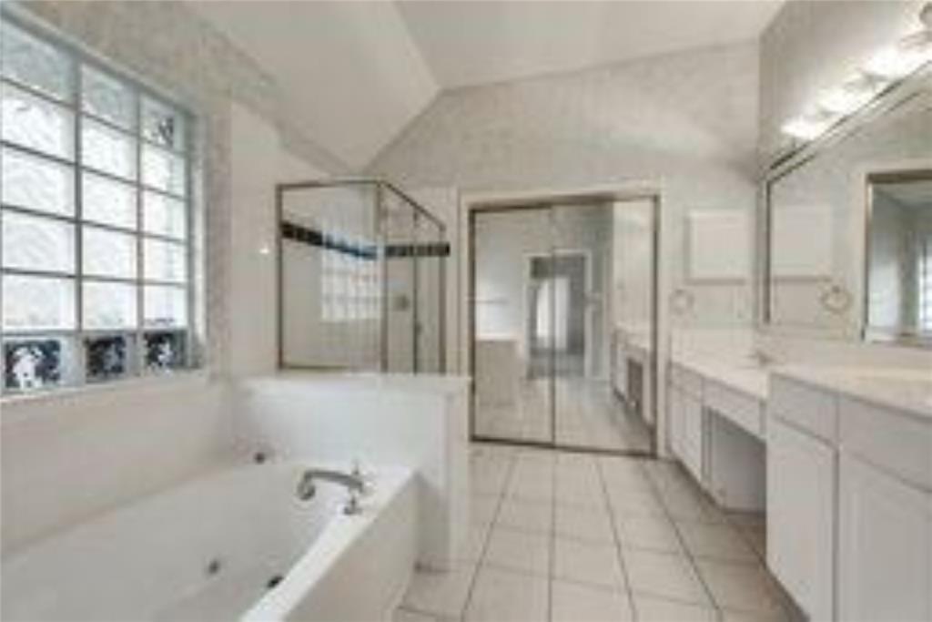 8417 Catskill Court Plano, TX 75025 - Photo 12 of 17 a spacious bathroom with a granite countertop tub shower and mirror