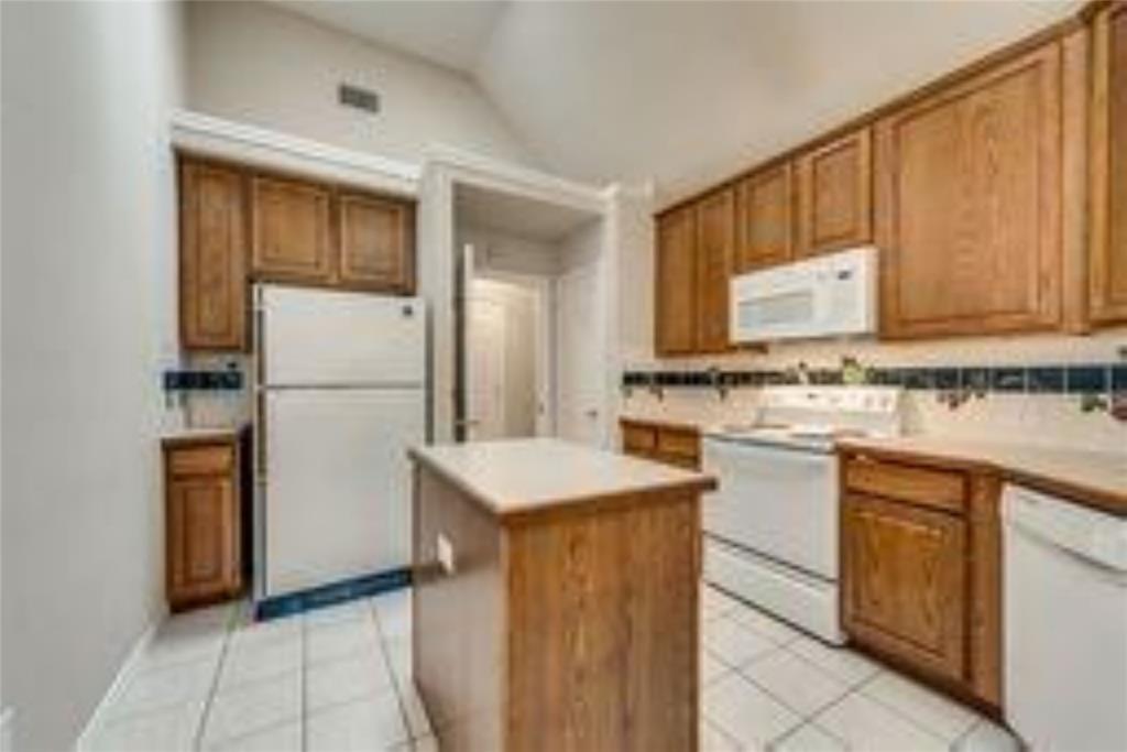 8417 Catskill Court Plano, TX 75025 - Photo 7 of 17 a kitchen with stainless steel appliances granite countertop a refrigerator and a stove top oven