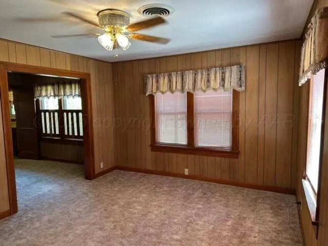 an empty room with windows and fan view