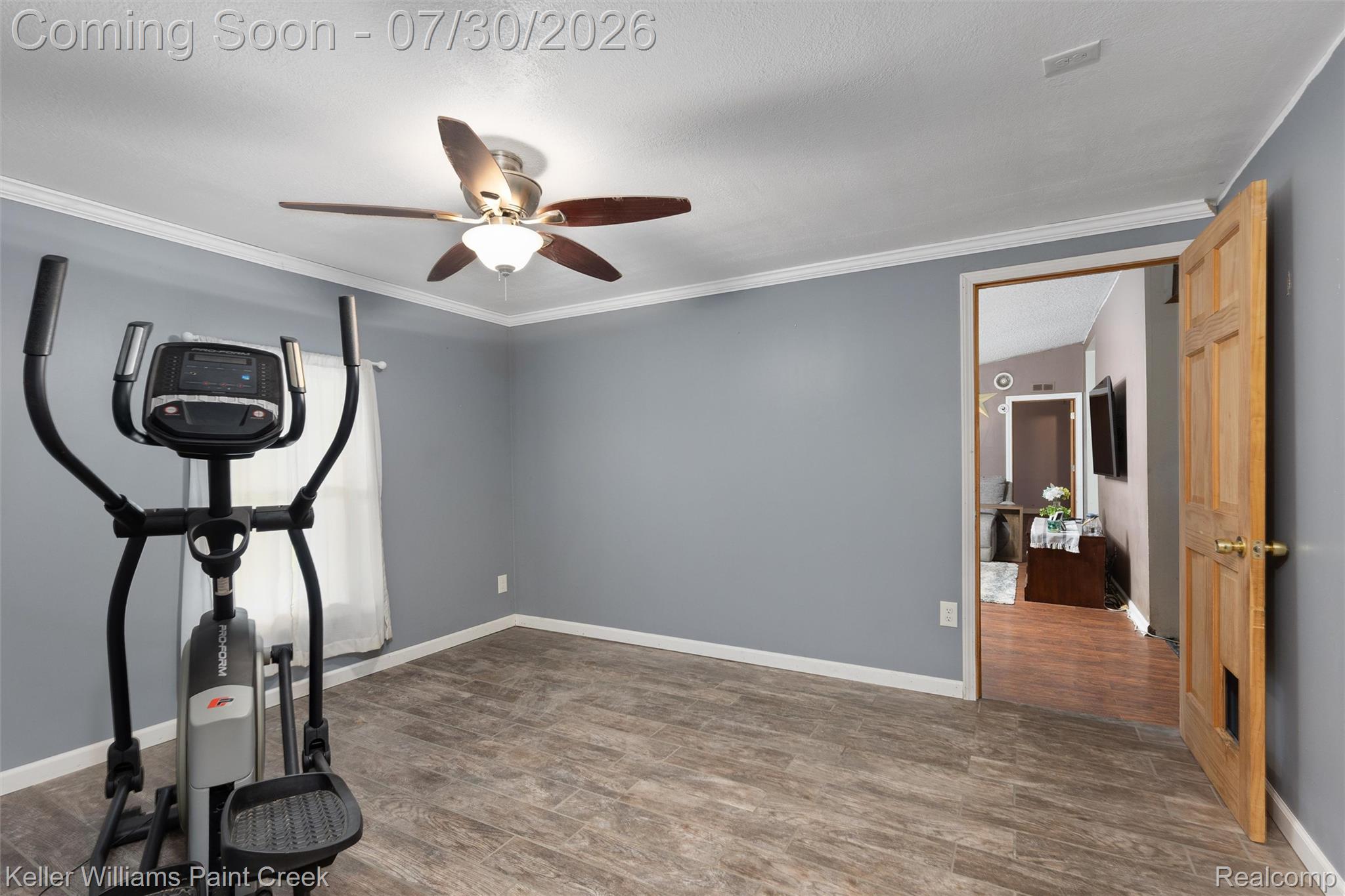 7544 Ravenswood Road Goodells, MI 48027 - Photo 17 of 42 Room featuring light gray walls, white crown molding, and wood-finish flooring