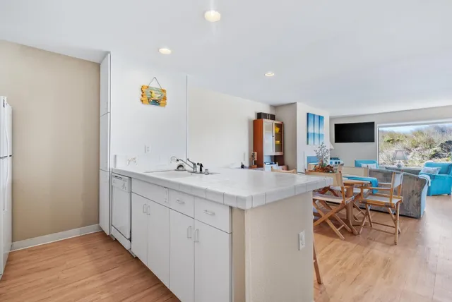 a view of a kitchen with kitchen island a sink stainless steel appliances and cabinets