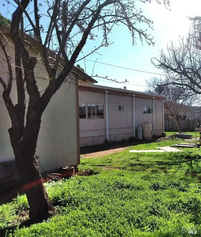a backyard of a house with large trees and a barn