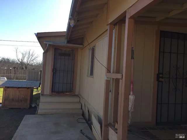 a view of a house with backyard and wooden fence