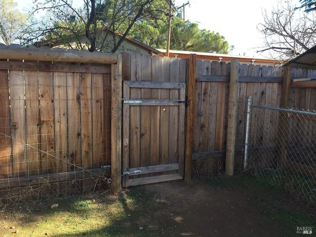 a view of a backyard with wooden fence