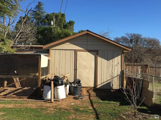 a view of a house with backyard water fountain and sitting area