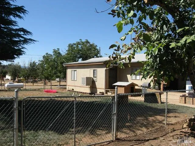 a patio with table and chairs and potted plants