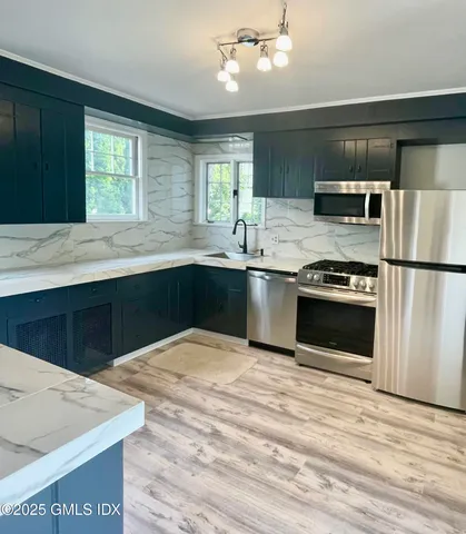 a kitchen with stainless steel appliances granite countertop a sink stove and refrigerator