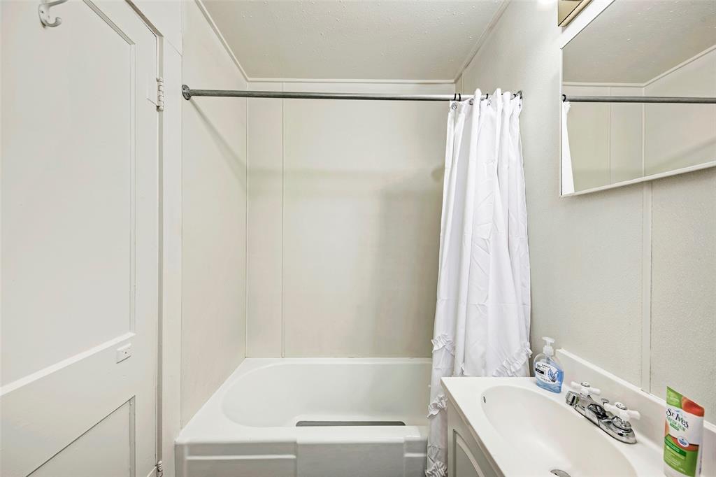 915 West 21st Street, Unit 2 Austin, TX 78705 - Photo 7 of 9 a bathroom with a shower curtain and a sink