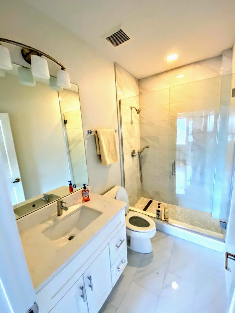 3203 North Ridgeway Avenue, Unit 2B Chicago, IL 60618 - Photo 11 of 17 a bathroom with a double vanity sink toilet mirror and shower
