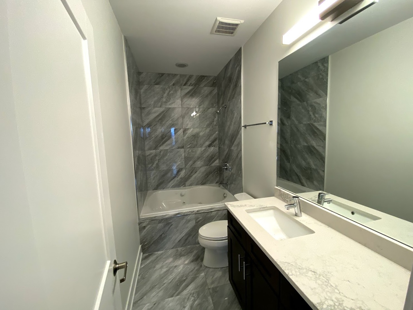 3203 North Ridgeway Avenue, Unit 2B Chicago, IL 60618 - Photo 17 of 17 a bathroom with a granite countertop sink a toilet a mirror and bathtub