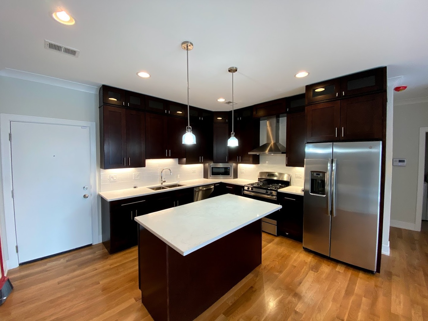 3203 North Ridgeway Avenue, Unit 2B Chicago, IL 60618 - Photo 4 of 17 a kitchen with a refrigerator a sink and wooden floor