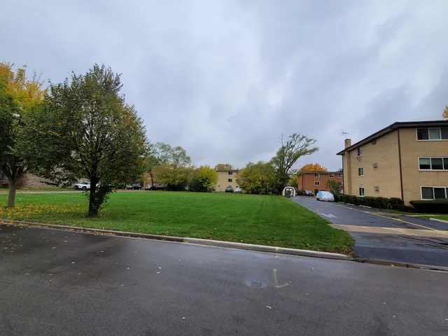 a view of a house with a big yard and large trees
