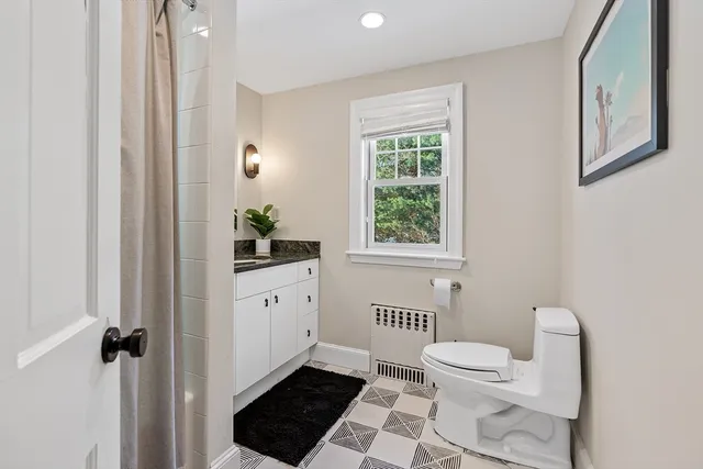 a bathroom with a toilet a sink and a window