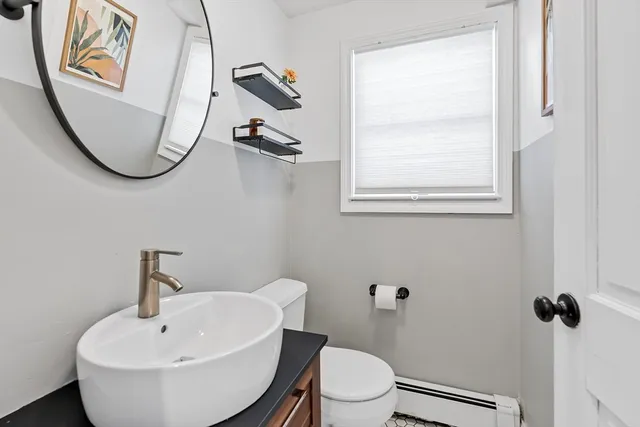 a bathroom with a toilet a sink and mirror