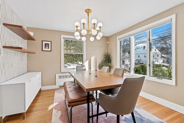 a view of a dining room with furniture a chandelier and wooden floor