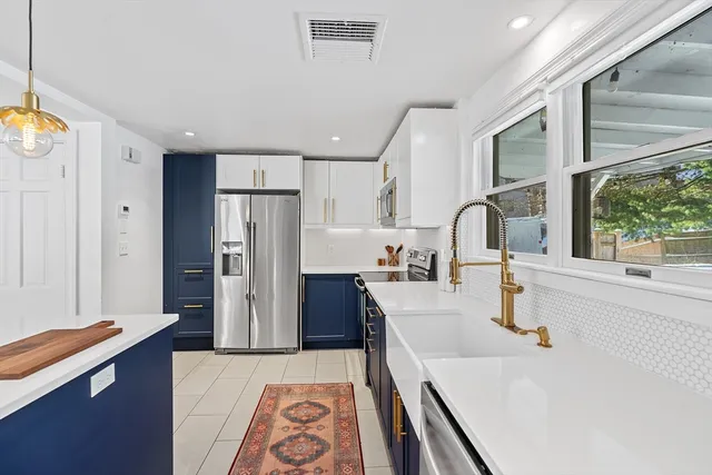 a large kitchen with stainless steel appliances a refrigerator and a sink
