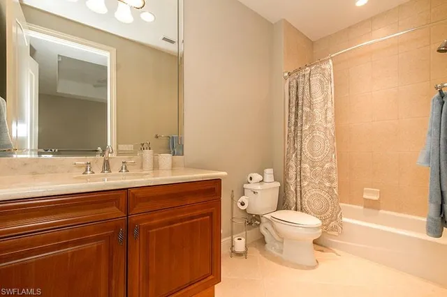 a bathroom with a granite countertop sink a toilet and a mirror