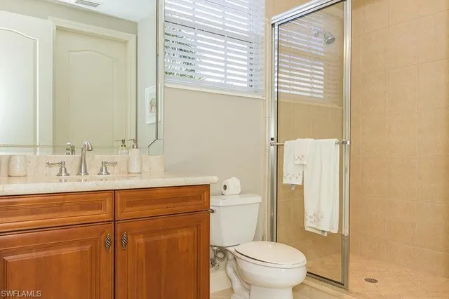 a bathroom with a granite countertop sink toilet and mirror