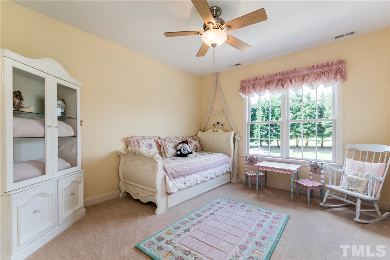 3413 Spartina Court Raleigh, NC 27606 - Photo 20 of 25 a bedroom with a bed and a chandelier