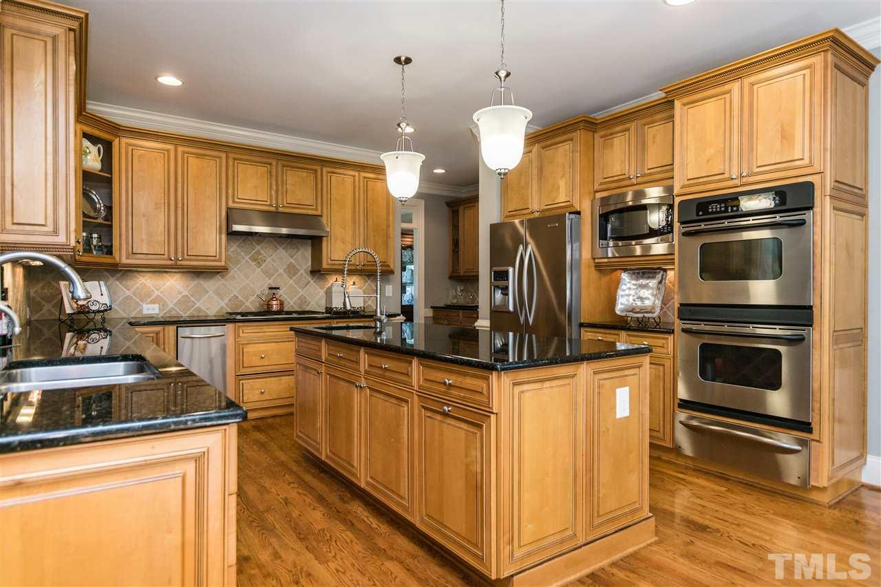 3413 Spartina Court Raleigh, NC 27606 - Photo 6 of 25 a kitchen with stainless steel appliances granite countertop a stove a sink and a refrigerator