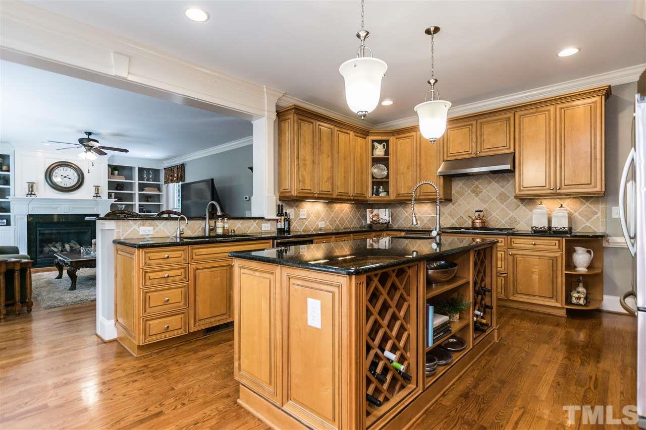 3413 Spartina Court Raleigh, NC 27606 - Photo 7 of 25 a kitchen with granite countertop a stove a sink a refrigerator and wooden cabinets