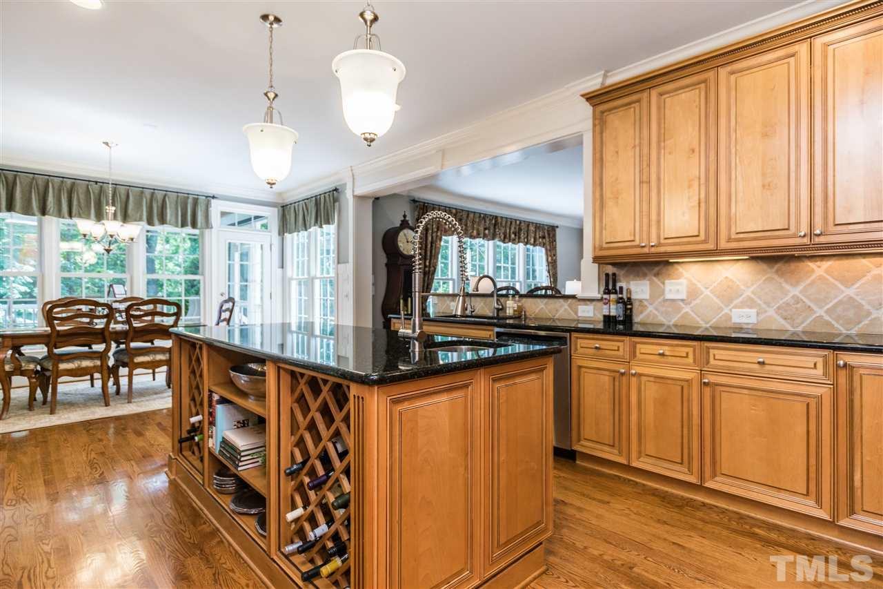 3413 Spartina Court Raleigh, NC 27606 - Photo 8 of 25 a kitchen with stainless steel appliances granite countertop a stove top oven a dining table and chairs with wooden floor