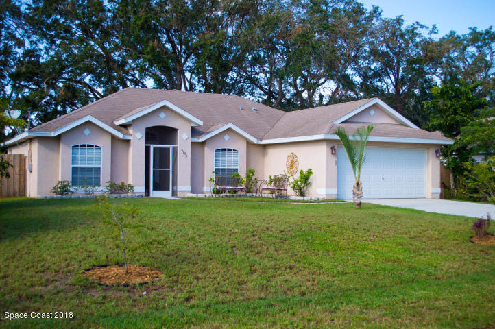 6130 Edison Street Cocoa, FL 32927 - Photo 1 of 15 a front view of a house with a yard and garage