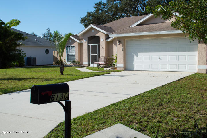 6130 Edison Street Cocoa, FL 32927 - Photo 2 of 15 a front view of a house with a yard and garage