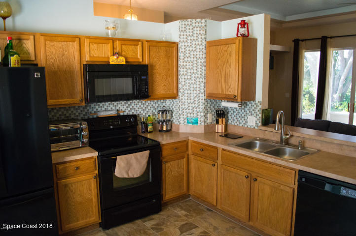 6130 Edison Street Cocoa, FL 32927 - Photo 9 of 15 a kitchen with stainless steel appliances granite countertop a sink stove and refrigerator