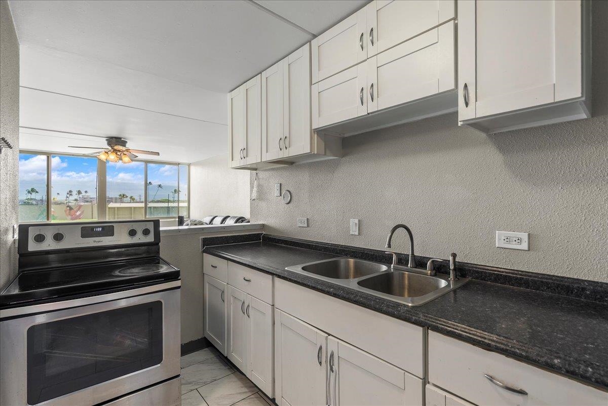 111 Kahului Beach Road, Unit B314 Kahului, HI 96732 - Photo 19 of 32 a kitchen with granite countertop white cabinets stainless steel appliances and sink