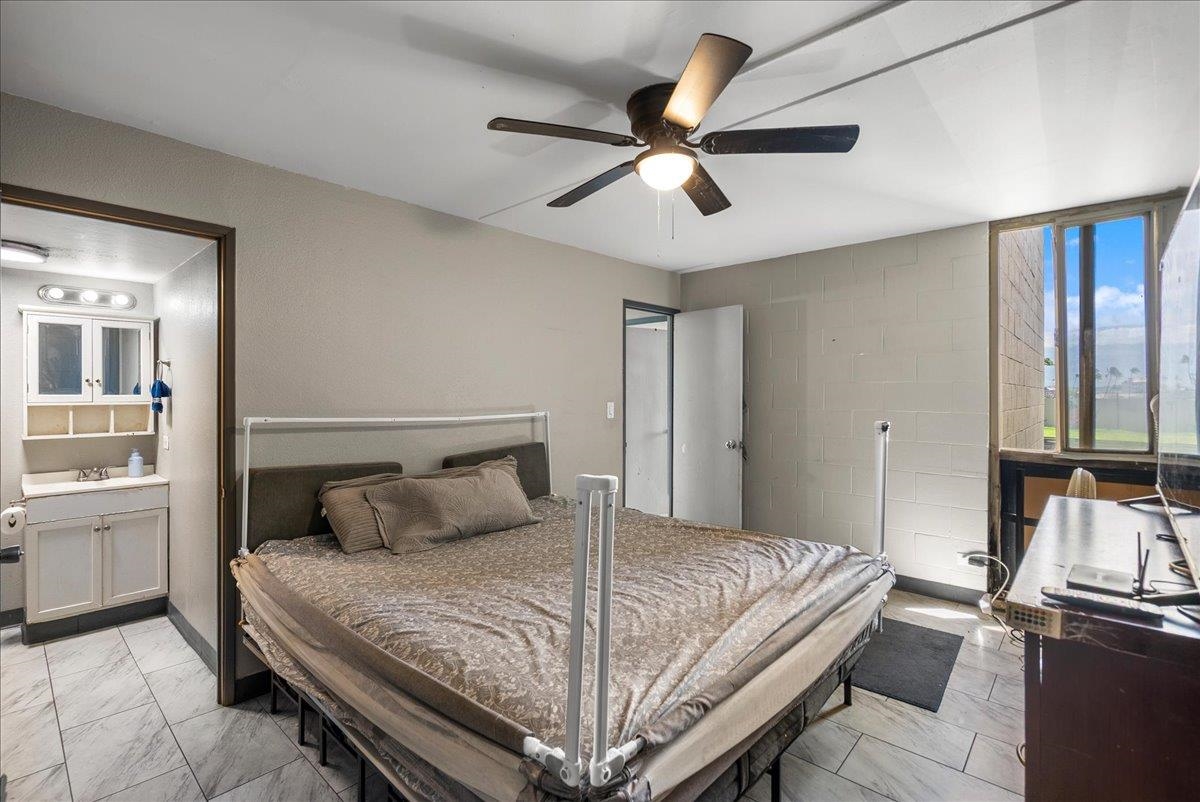 111 Kahului Beach Road, Unit B314 Kahului, HI 96732 - Photo 5 of 32 a bedroom with a bed and a chandelier