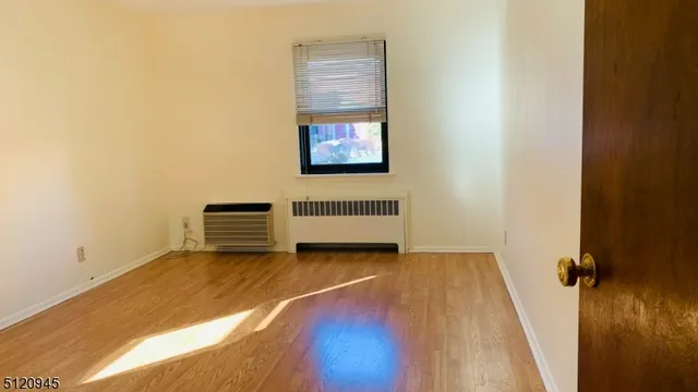 a view of a room with wooden floor and window