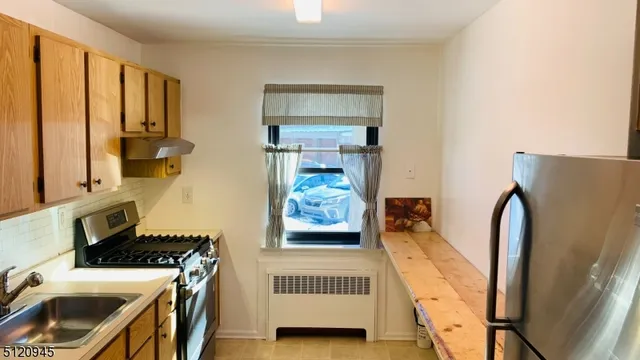 a view of a kitchen with fridge and wooden floor
