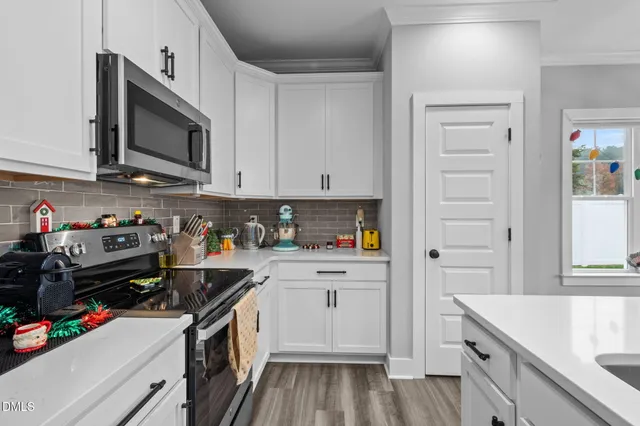 a kitchen with granite countertop a sink dishwasher stove and cabinets with wooden floor