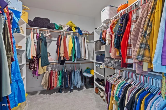 a view of walk in closet with clothes