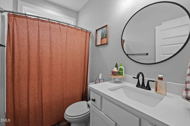 a bathroom with a sink mirror and toilet