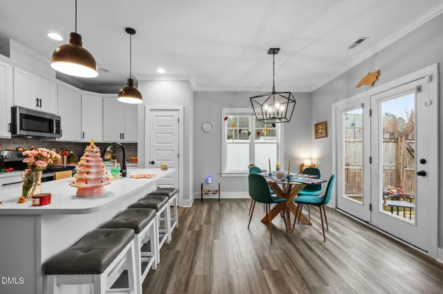 a view of a dining room with furniture a chandelier and wooden floor