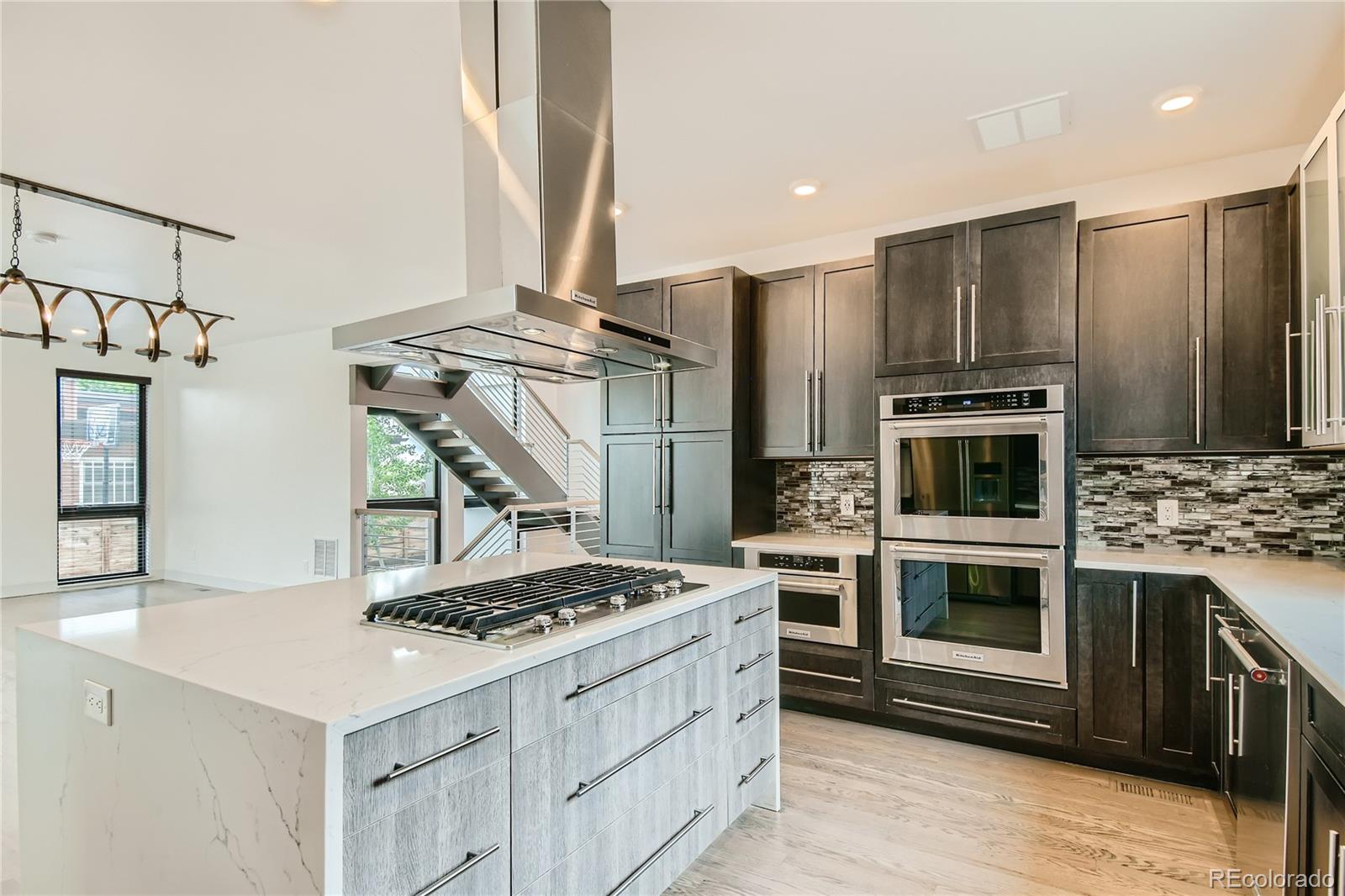 1609 Xavier Street Denver, CO 80204 - Photo 11 of 36 a kitchen with stainless steel appliances kitchen island a stove and a refrigerator