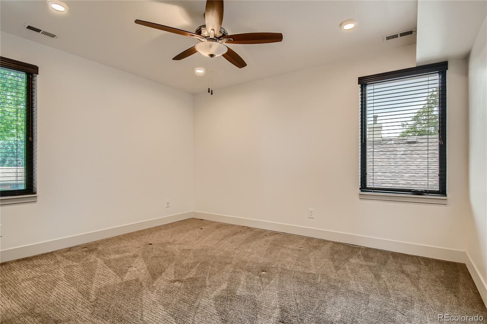 1609 Xavier Street Denver, CO 80204 - Photo 22 of 36 en empty room with windows and ceiling fan