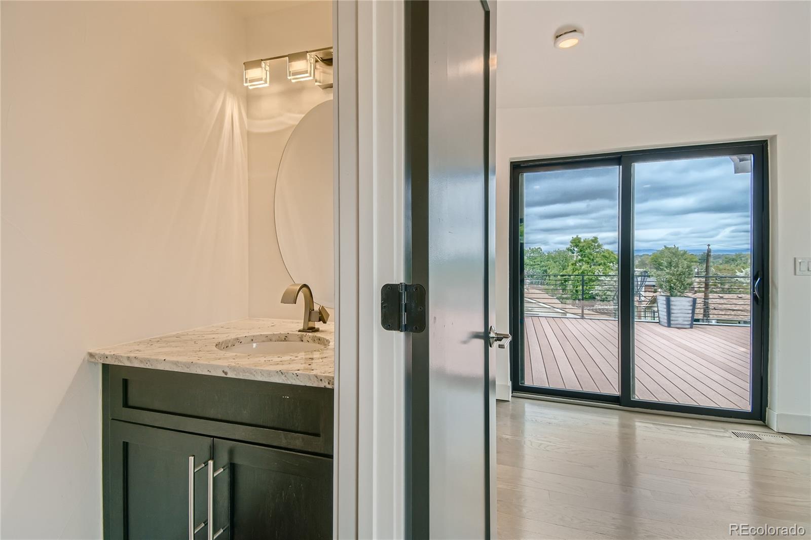 1609 Xavier Street Denver, CO 80204 - Photo 26 of 36 a bathroom with a granite countertop sink and a mirror
