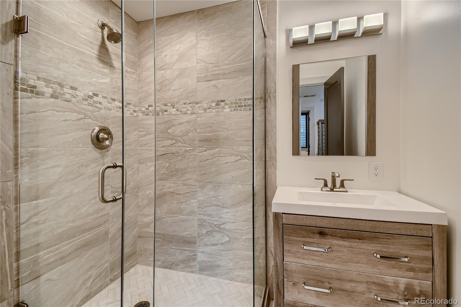 1609 Xavier Street Denver, CO 80204 - Photo 28 of 36 a bathroom with a shower sink and mirror