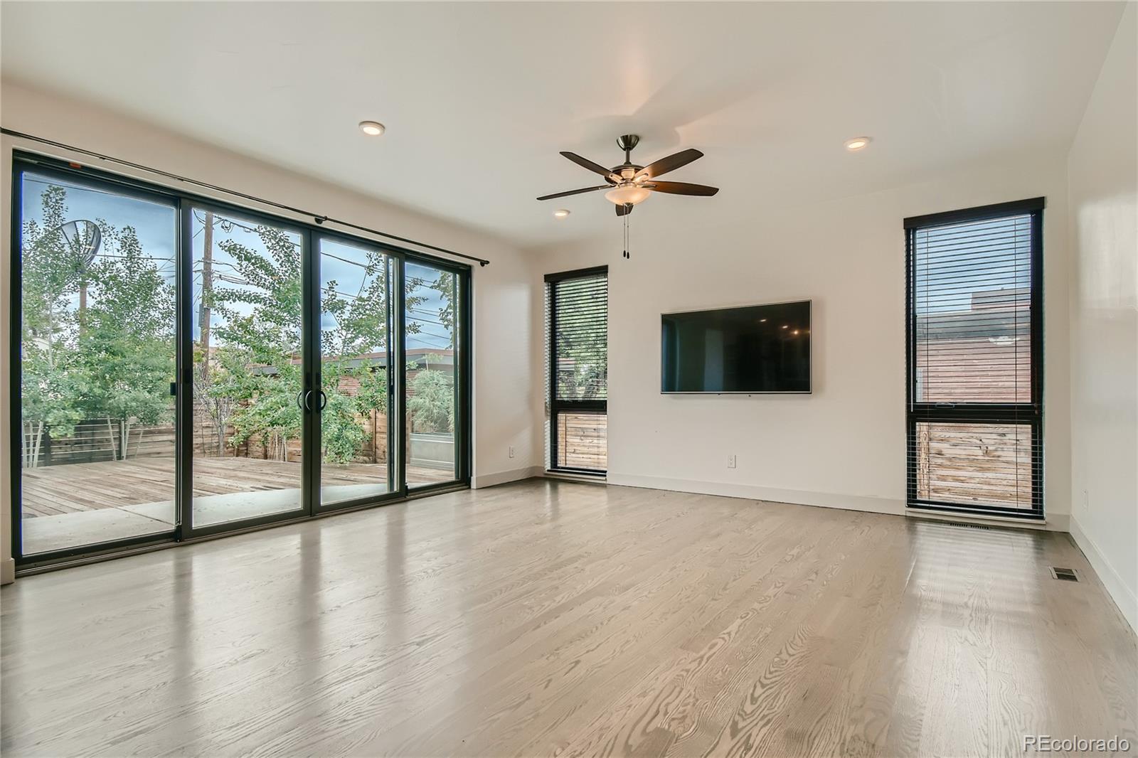 1609 Xavier Street Denver, CO 80204 - Photo 5 of 36 a view of an empty room with a window and wooden floor